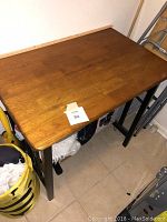 Rectangular wooden table with smooth brown finish and black metal legs.