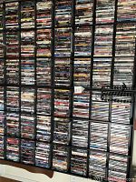 Wall-mounted shelf completely filled with DVDs in cases