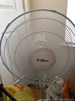 Photo shows the front side of the Hawaiian Breeze floor fan with visible logo, grille, and blades.