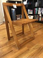 Side view of the mid-century wooden folding chair showing slatted wooden seat and folding frame.