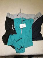 Two pairs of shorts overlapped showing grey waistbands and colour variations