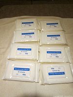 Eight sealed packs of bactericidal wipes displayed on surface
