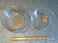 Two clear Pyrex bowls side by side with ruler for scale