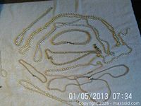 Multiple faux pearl necklaces laid out showing quantity and variety