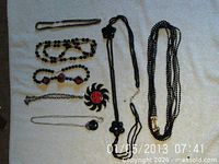 All seven necklaces laid out on white surface