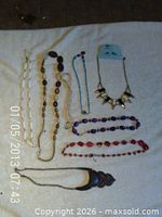 All eight necklaces laid out on towel