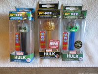 Front view of three boxed Hulk Pop! Pez variants