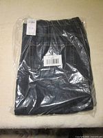 Folded pair of jeans inside sealed plastic bag