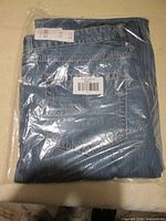 Jeans folded in plastic packaging showing rear pocket
