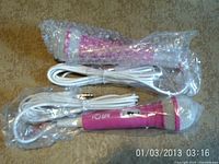 Two bubble-wrapped pink microphones with white cords