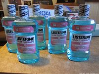 Front view of five sealed 1 L Listerine Gum Therapy bottles