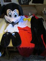 All costume pieces laid out: head, bodysuit, shorts, bow tie, gloves, shoe covers