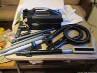 Vacuum with hose, wands, attachments spread on table