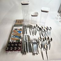Overview of flatware pieces, three canisters, boxed dividers, and boxed shakers