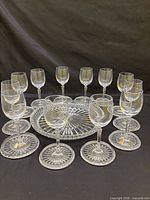 Full set of wine glasses surrounding serving plate and coasters