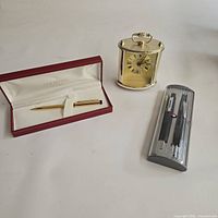 Lot overview showing gold-tone Sheaffer pen in box, Gruen mantel clock and Sheaffer case