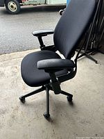 Full view of black office chair on casters
