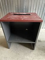Front view of laminate stand showing open shelf and top with grommet