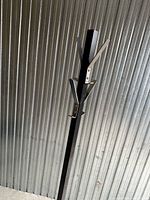 Upper section of black metal post showing two silver double hooks
