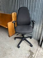 Front view showing chair design, upholstery, armrests, base and casters