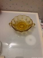 Top view of amber scalloped candy dish showing starburst base and both handles