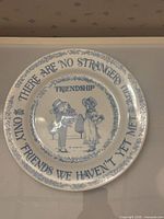 Front of blue on white porcelain plate showing motif and text