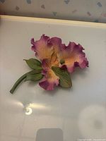 Top view of Capodimonte porcelain flower figurine showing pink-peach petals and green leaves