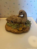 Front view of ceramic duck with ducklings on base