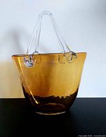 Front view of amber basket-shaped glass vase with clear handles