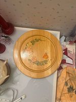 Top view of round wooden tray showing painted motif