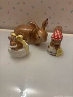 Three rabbit-themed figurines displayed together