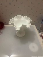Overall view of white milk glass hobnail compote with ruffled edge