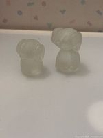 Two clear frosted glass dog figurines side by side