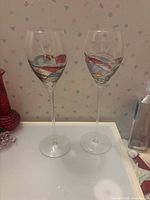 Full view of both wine glasses standing upright