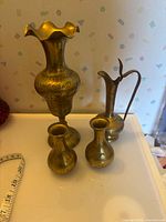 Group shot of all four brass vessels showing sizes and designs