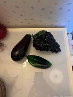 Group shot of three glass fruit/vegetable paperweights