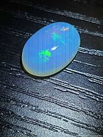 Front view of oval crystal opal displaying play-of-color