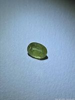 Top view of oval green sapphire on white background