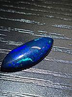 Marquise cabochon black opal showing blue and green play of colour