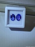 Front view of two oval tanzanites in display box