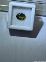 Front view of oval sapphire in case, illustrating color zoning