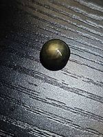 Top view of black star sapphire showing star asterism