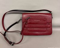Front view of red leather crossbody bag with strap extended