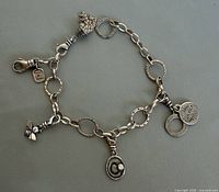 Full view of Silpada sterling charm bracelet showing four charms and lobster clasp
