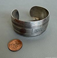 Front view showing width, engraving, monogram and scale next to penny