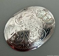 Front of engraved sterling silver oval brooch