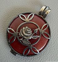 Front view showing rose motif on red jasper in silver frame