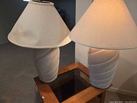 Both matching pottery lamps with shades on tabletop
