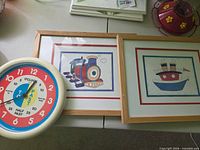 Overall view of two framed prints and teaching clock