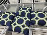 Four matching pillows on patio table showing pattern